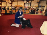 Lori Toth with a mostly black Tibetan Terrier in the show ring at the World Dog Show in Portugal, 2001